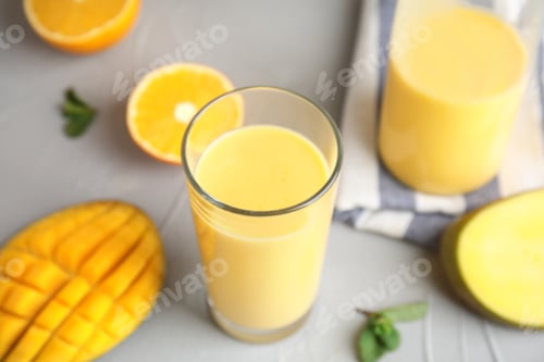 Vista previa: Fresh mango drink and tropical fruits on table