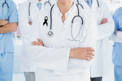 Preview: Mid section of team of doctors with black ribbon standing with their hands folded