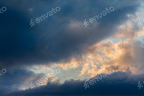 Preview: Dark cloudy sunset skies with an orange colored part, full frame background