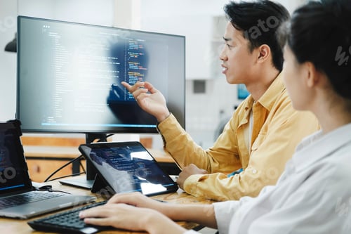 Preview: Team of young computer programmers cooperating while working on desktop PC in the office.