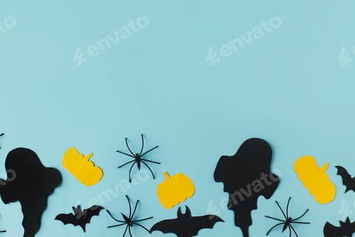 Preview: Happy Halloween. Black ghosts, spiders, bats and yellow pumpkins on blue background flat lay