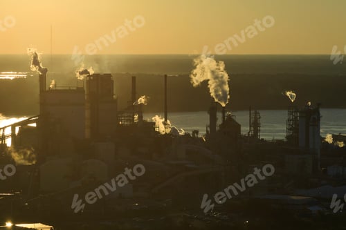 Preview: Large factory structure with smoke from production process rising up polluting atmosphere