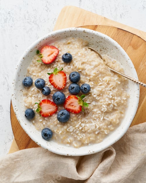 Preview: Oatmeal porridge rustic with berries, dash diet, on white wooden background top view