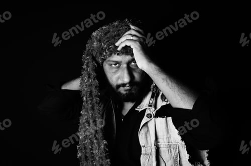 Preview: Grayscale portrait of a South Asian male in long headwear on a dark background