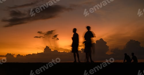 Preview: Silhouetted people's movements in the evening against a beautiful sunset sky.