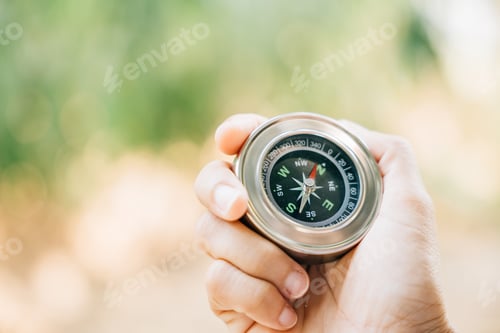 Preview: Hiker searches for direction in the forest holding a compass to overcome confusion. The compass in