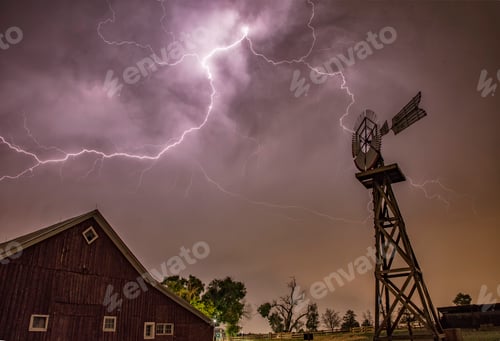 Preview: Dramatic lightning behind a windmill and barn