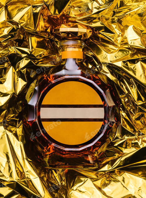 Preview: bottle of cognac on golden foil background
