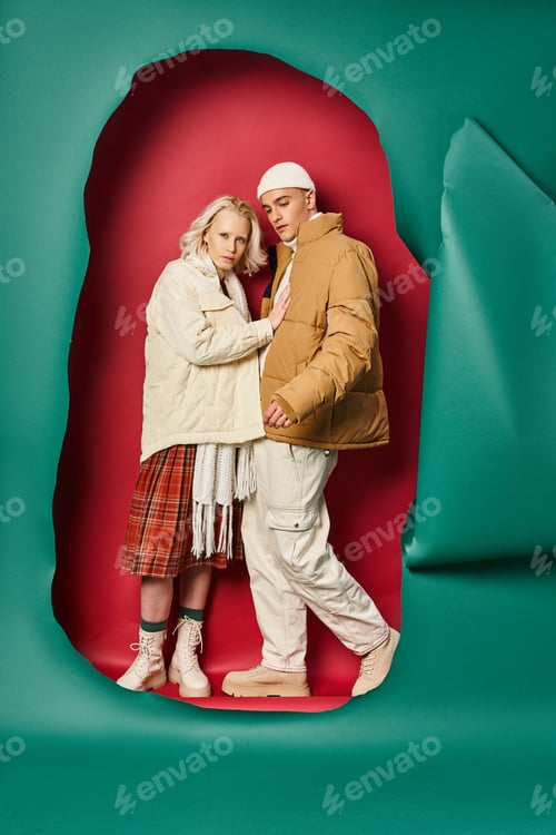Preview: woman in outerwear and plaid skirt posing with boyfriend near torn turquoise and red backdrop