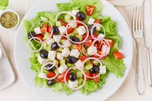 Preview: Greek salad on white plate on old rustic white wooden table, fresh salad