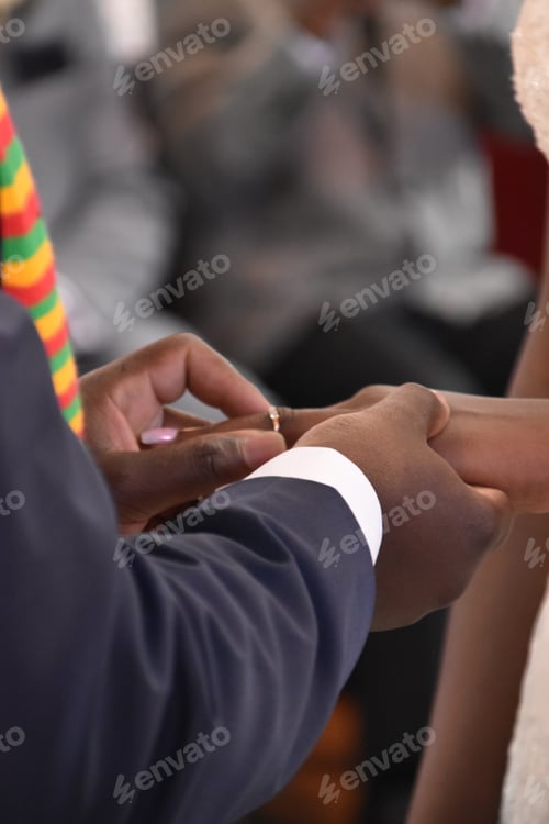 Preview: african groom putting ring on his bride's finger