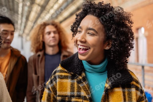Preview: Young woman laughing with friends at the train station