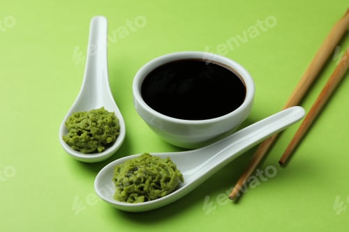 Preview: Wasabi, soy sauce, and chopsticks on green background