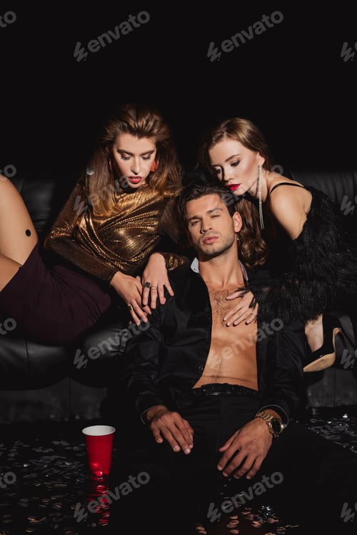 Preview: attractive and stylish women hugging handsome man isolated on black
