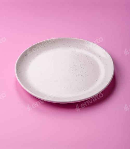 Preview: An empty round ceramic plate on a pink background as a kitchen utensil. An empty plate