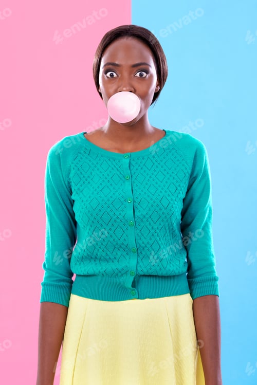 Preview: Studio shot of an attractive young woman blowing a gum bubble against a colorful background
