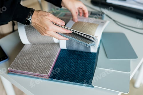Preview: woman choosing fabrics swatches for sofa in store. Interior designer looking materials for home