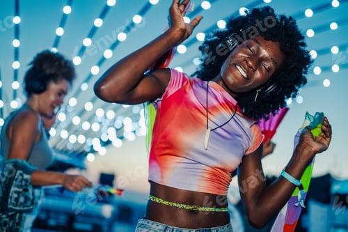 Preview: Young woman dancing and enjoying music at summer festival