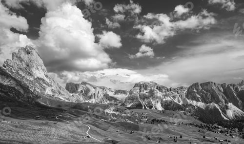 Preview: Grayscale view of Dolomite Mountains under dramatic cloudy sky in Italy