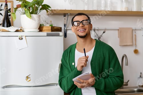 Preview: Charming young man enjoys a peaceful moment of creativity in a cozy home kitchen setting