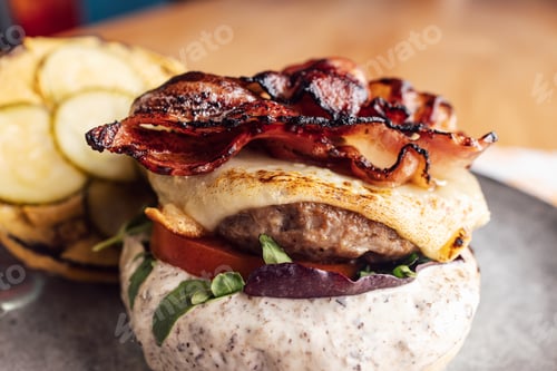 Preview: Delicious Gourmet Bacon Cheeseburger with Fresh Greens on a Modern Styled Plate
