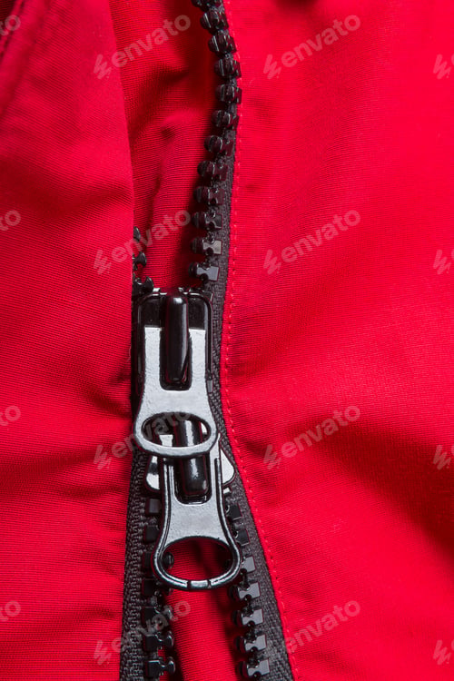 Preview: Fragment of red jacket with black zipper. ziplock background. Close up.