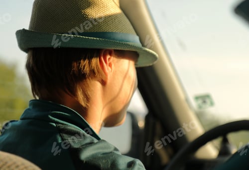 Preview: Blonde woman with a hat driving a car