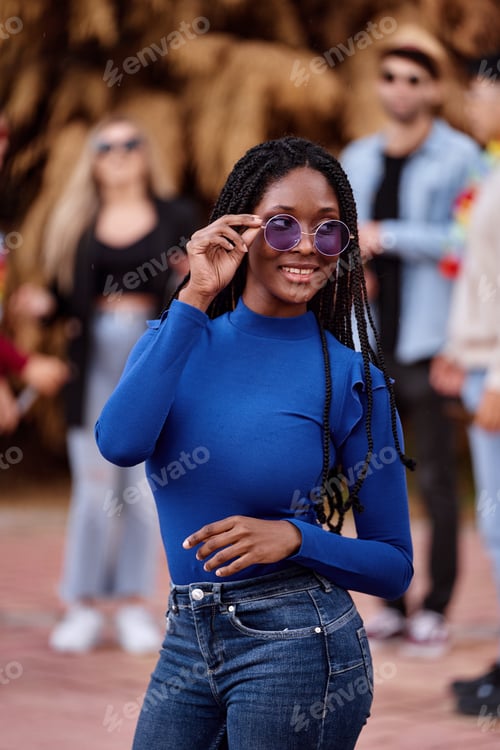 Preview: Beautiful african american woman with dreadlocks and sunglasses looking at camera