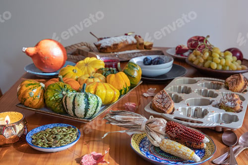 Preview: Thanksgiving table with pumpkins, pumpkin seeds, dry corn, grapes, baked cookies