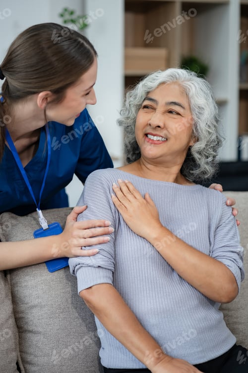 Preview: young caregiver assists her elderly woman patient at a nursing home.