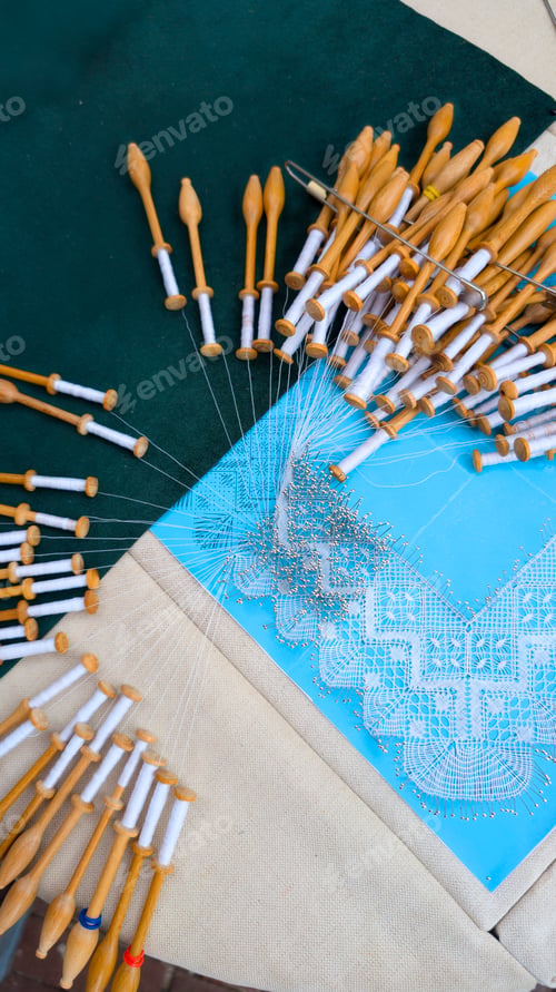 Preview: Bobbin Lace Crafting with Pins and Wooden Tools on Fabric Surface