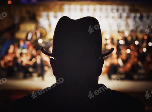 Silhouette of Man in Hat Watches Orchestra
