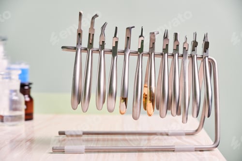 Preview: Jar of cotton rolls and orthodontic instruments for dental procedure.