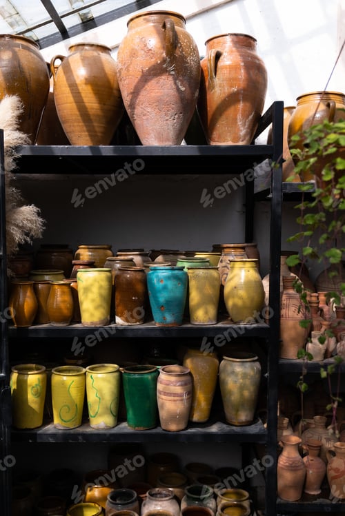 Preview: Many unique handmade colorful clay jugs and vases of various shapes on shelf in local market