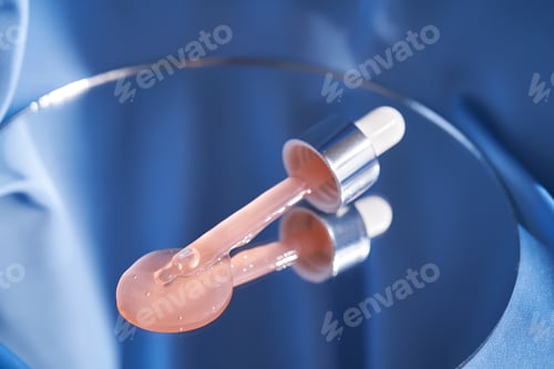 Preview: Bottle with pink serum on a blue background.