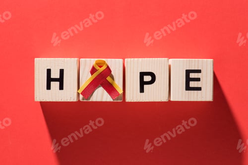 Preview: top view of ribbon and lettering hope from wooden cubes on red background, world hepatitis day