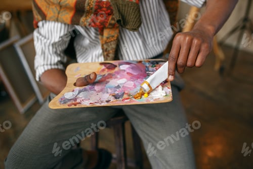 Preview: Male painter prepares colorful paints, art studio