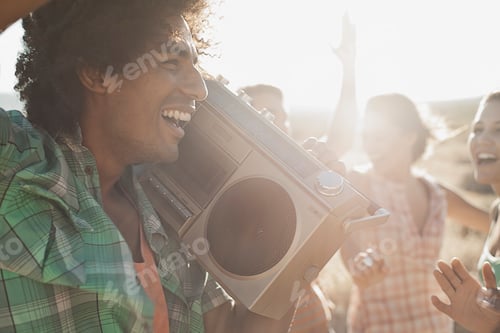 Preview: Group of young people, men and women walking on the open road with a boombox.