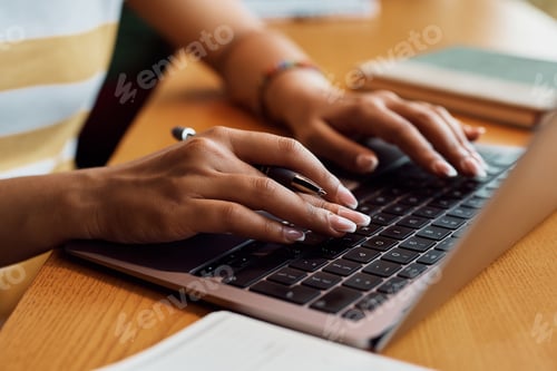 Preview: Close up of black woman working on laptop in a cafe.