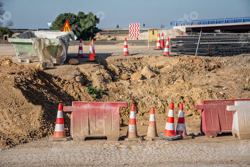 Preview: Heap of soil adjacent to bright orange and white traffic cones