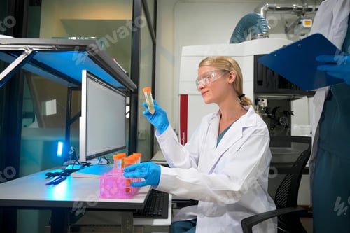 Preview: Female scientist conducting research in laboratory using glassware and technology