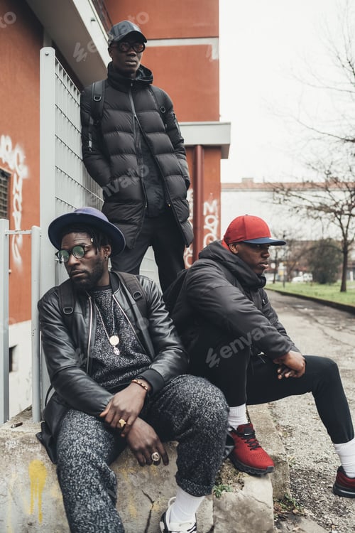 Preview: three young african men posing sitting together in the street