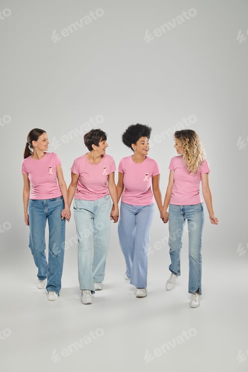 Preview: breast cancer awareness, positive multicultural women with pink ribbons walking together on grey