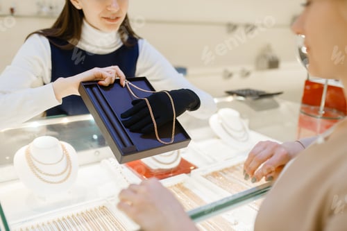Preview: Woman choosing golden chain in jewelry store