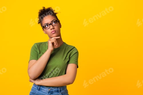 Preview: Black woman in glasses thinking about question, touching chin