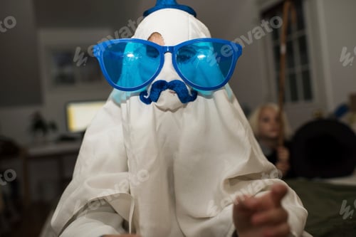 Preview: Girl dressed up as ghost with mustache and over sized sunglasses