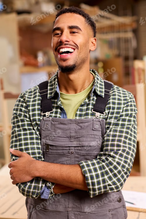 Preview: Portrait Of Male Apprentice Working As Carpenter In Furniture Workshop
