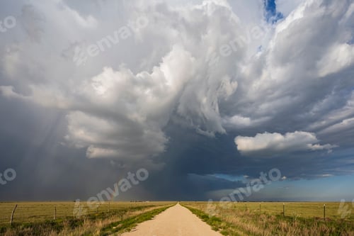 Preview: Back Side of a Supercell with a Rainbow above a road reaching the horizon.