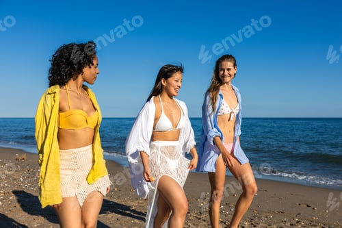 Preview: Multiethnic young women walking and enjoying summer vacation on the beach