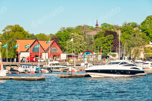 Preview: A scenic waterfront on Djurgarden with boats docked in a marina, colorful Swedish